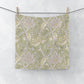 Floral patterned wqshcloth hanging on a line against a white background