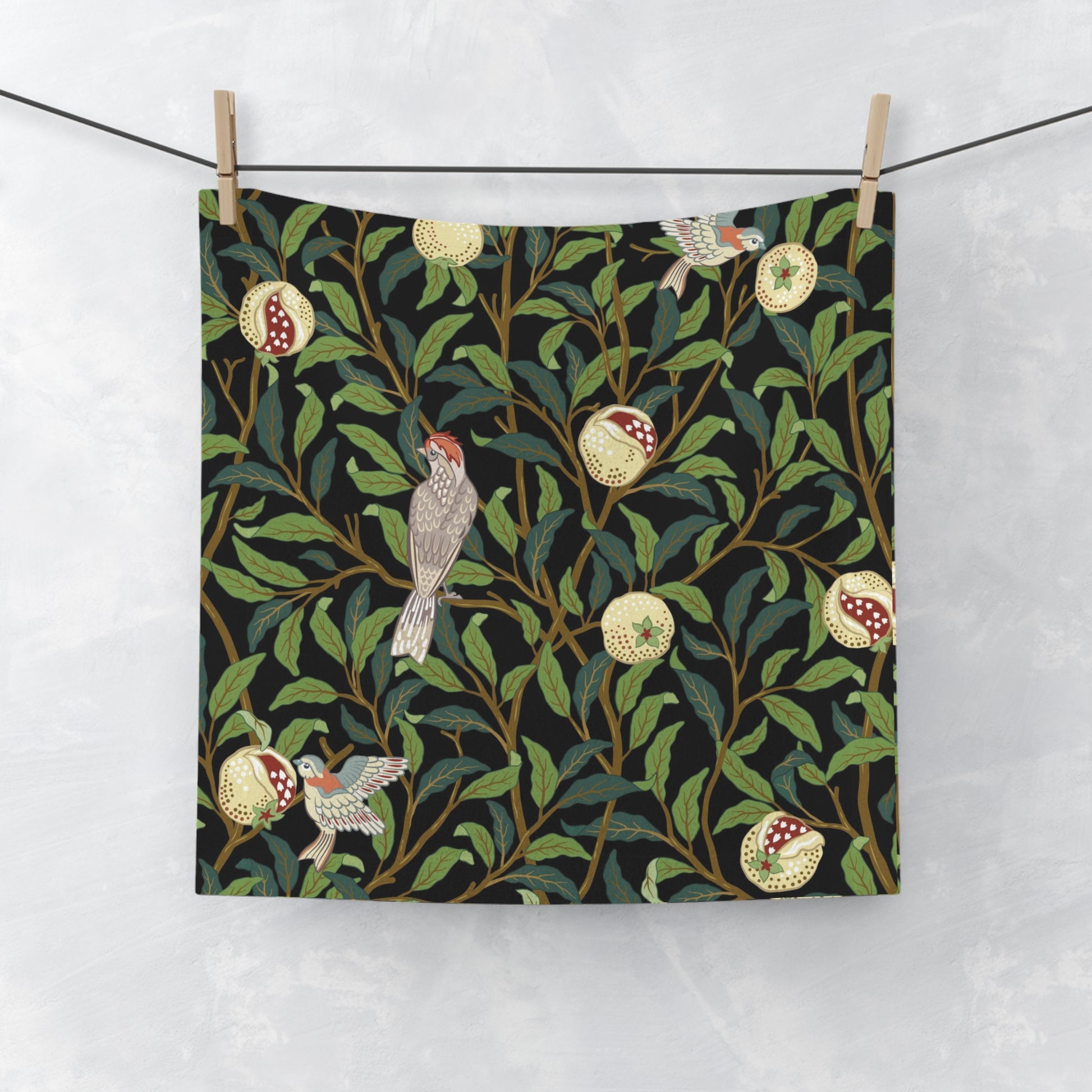 A white washcloth with a floral pattern featuring birds and pomegranates, inspired by the William Morris design.