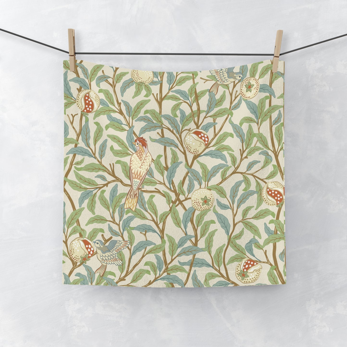 A white washcloth with a floral pattern inspired by William Morris, featuring birds and pomegranate designs on a parchment background.