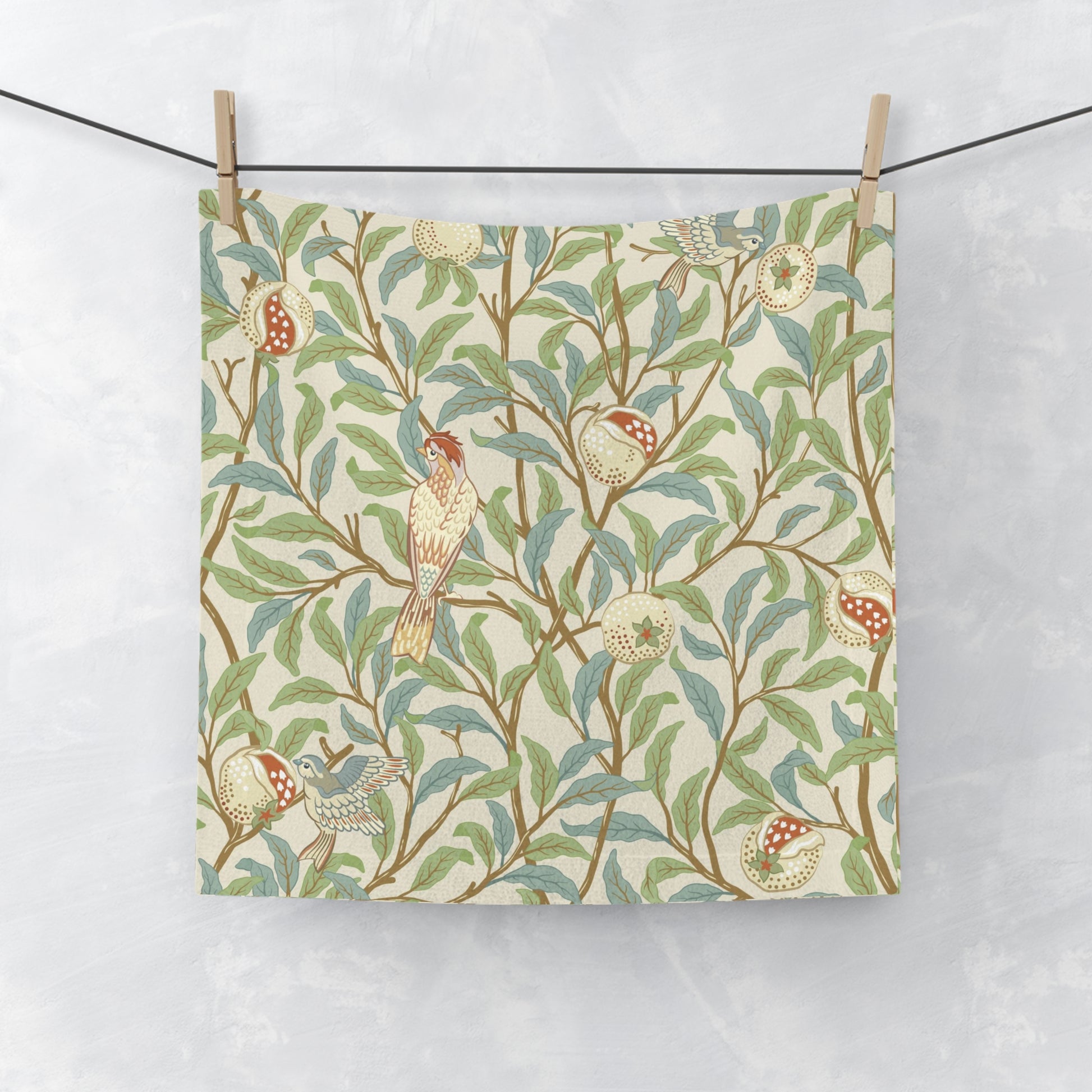 A white washcloth with a floral pattern inspired by William Morris, featuring birds and pomegranate designs on a parchment background.
