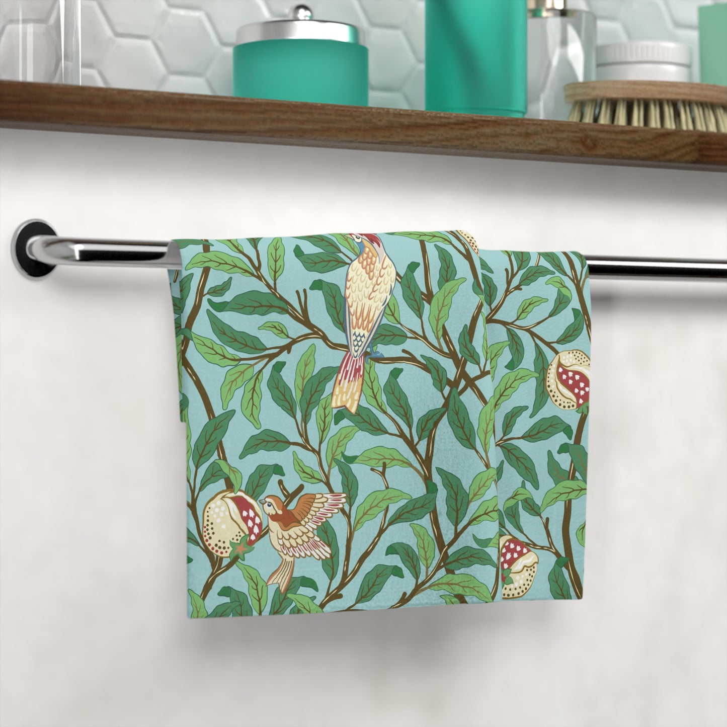 A washcloth with a floral William Morris & Co pattern featuring birds and pomegranates on a Tiffany Blue background.