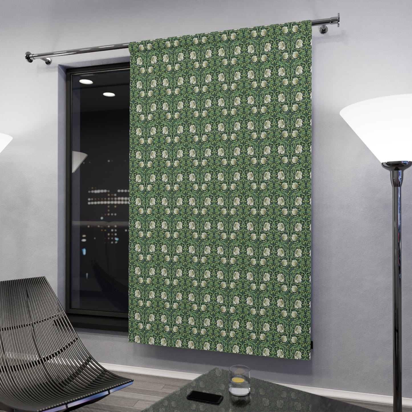 Green patterned curtain in a modern room with a lamp and chair.