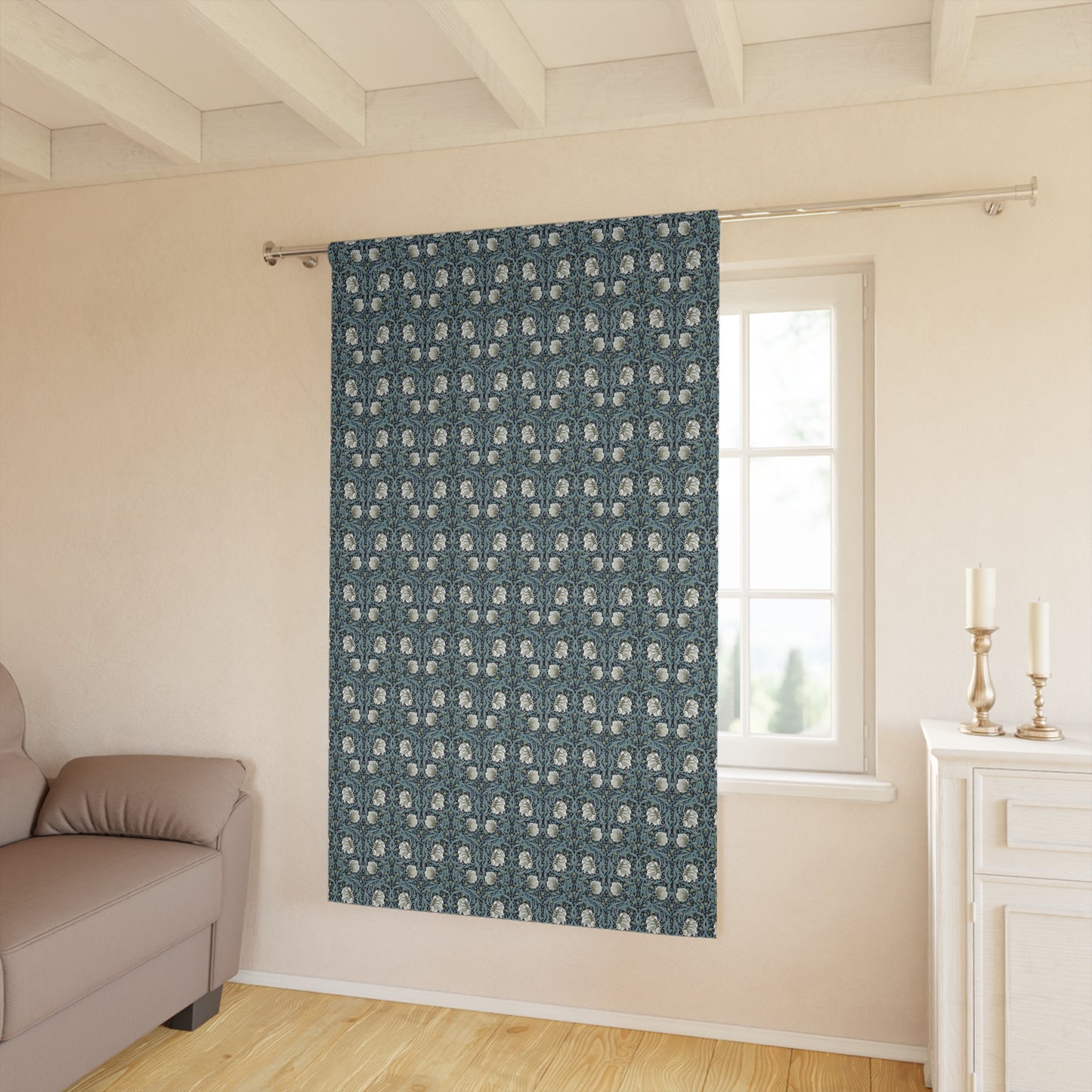 Patterned blue curtain hanging in a room with a sofa and window.