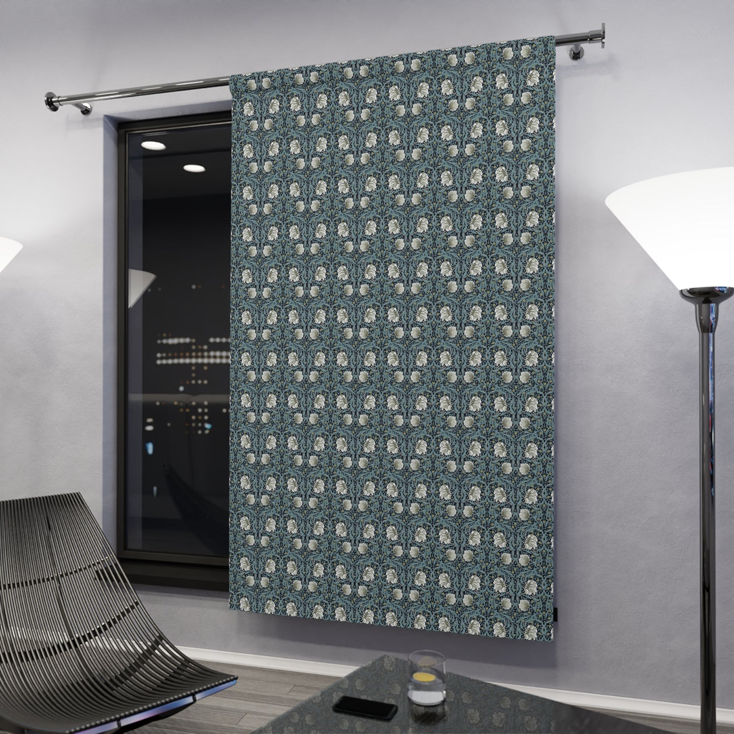 Patterned curtain in a modern room with a television and lamp.