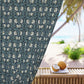 Decorative curtain with floral pattern in front of a beach setting with coconuts on a table.