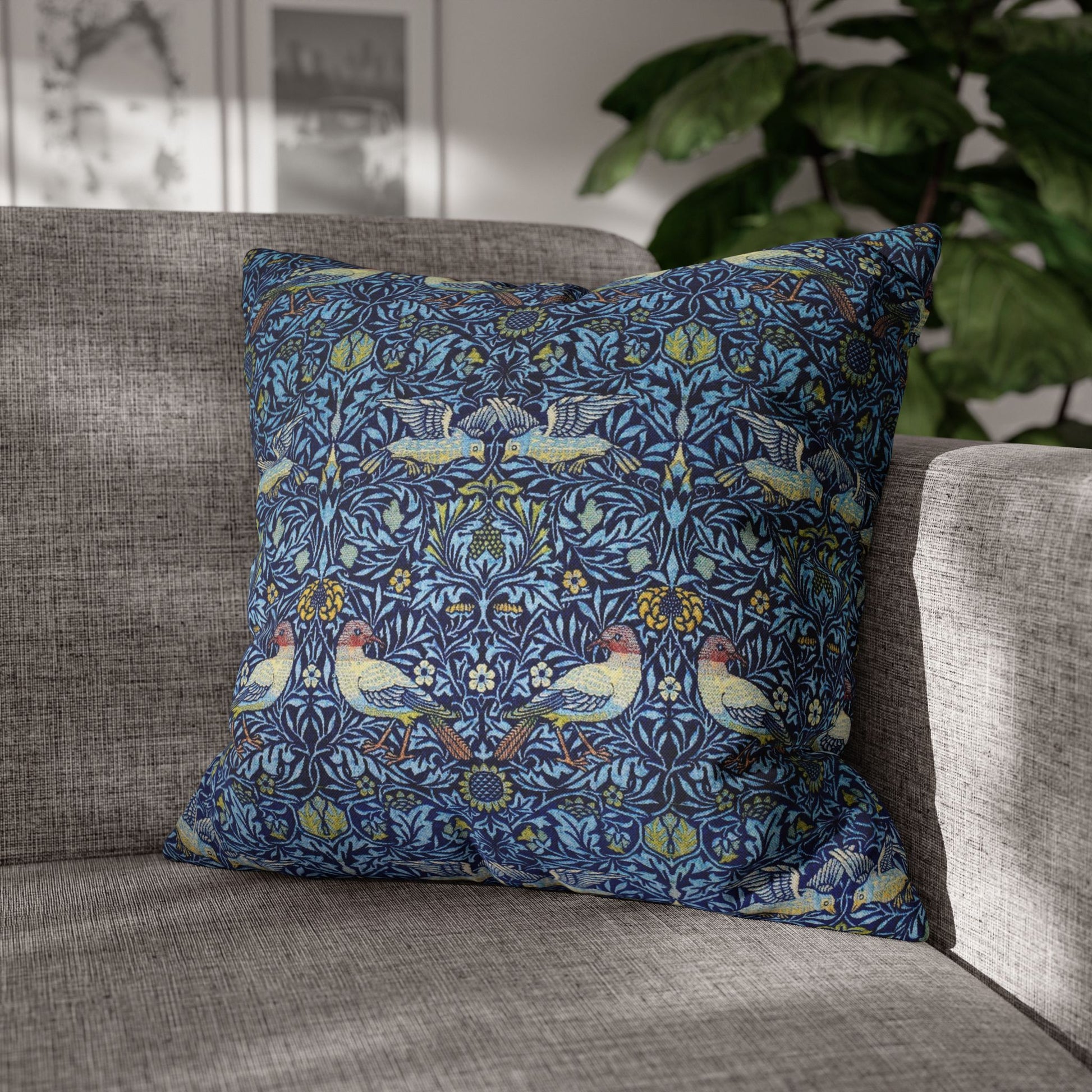 Decorative pillow with floral and bird pattern on a gray sofa