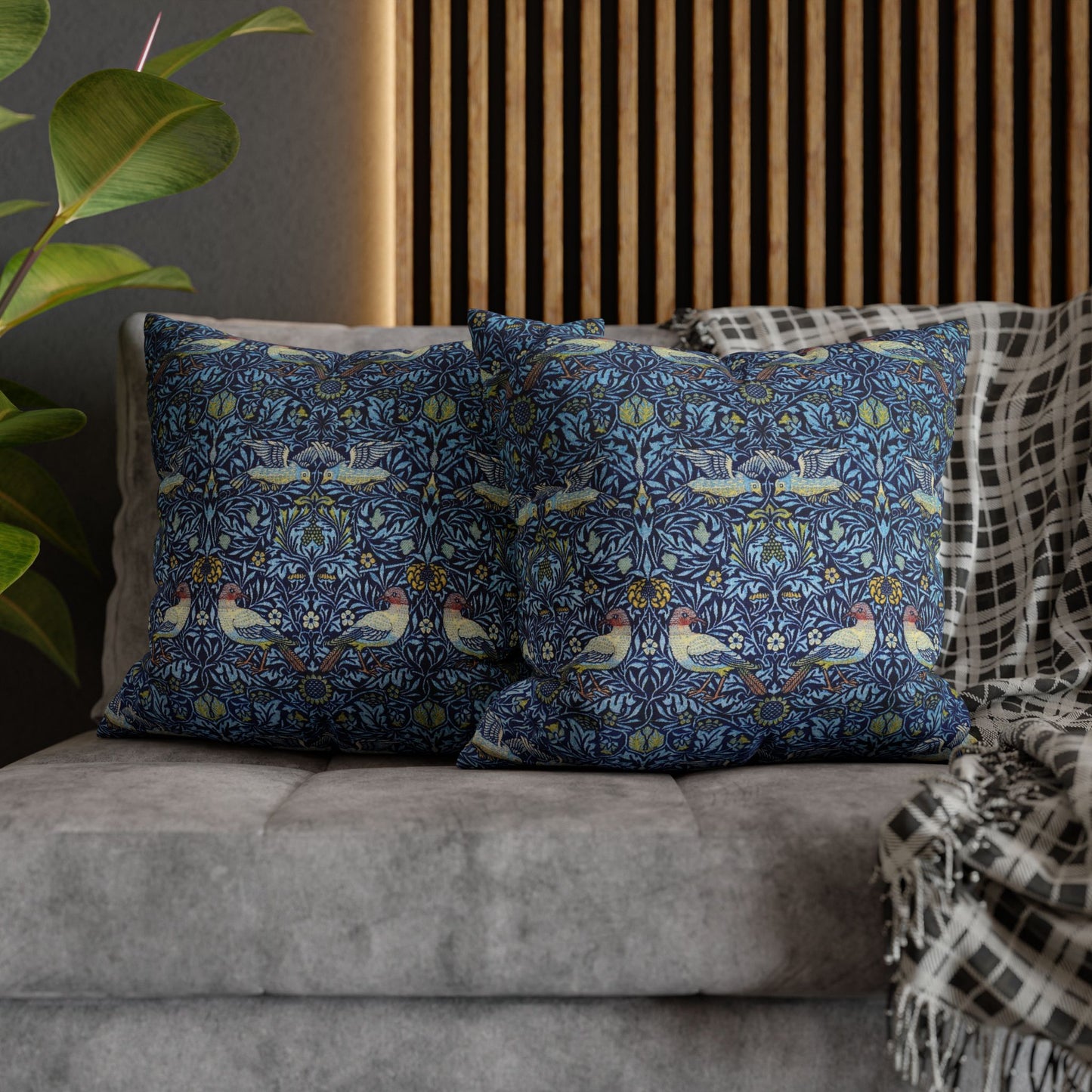 Decorative pillows with a floral pattern on a gray sofa.