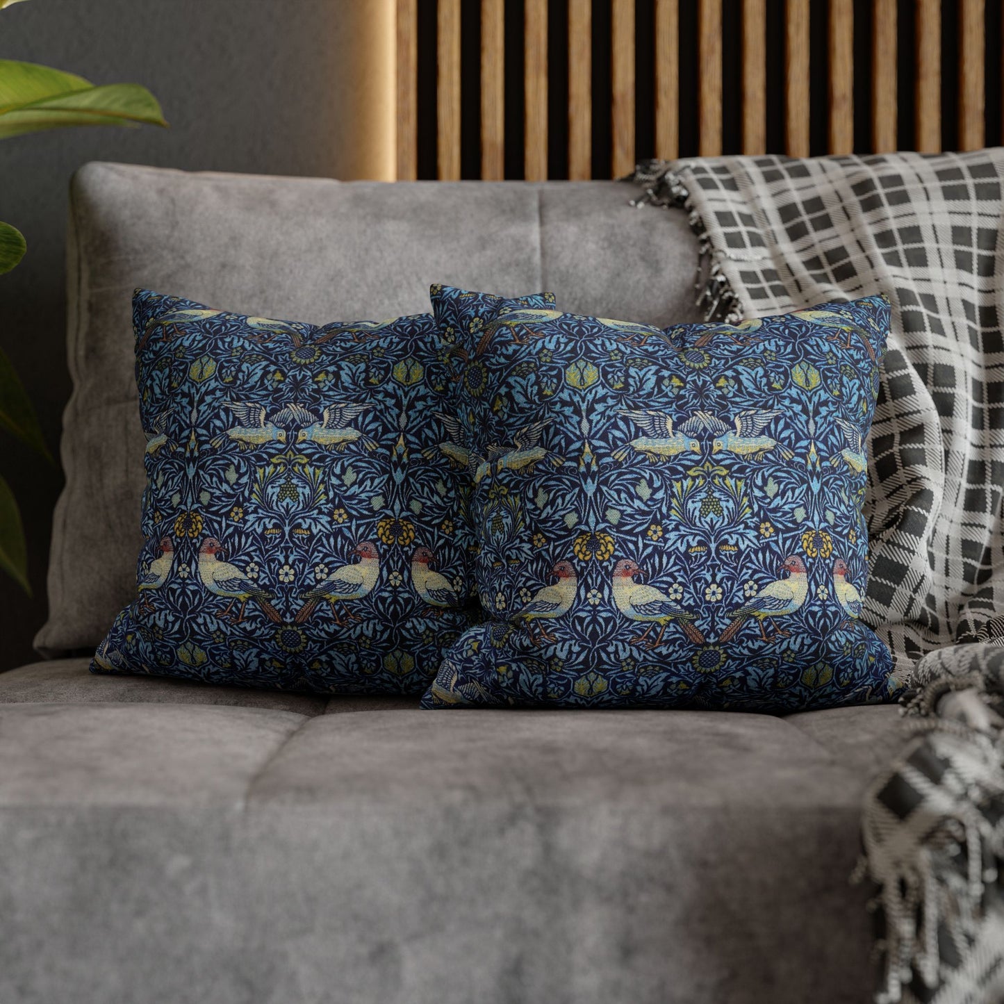 Decorative pillows with a floral pattern on a gray sofa.