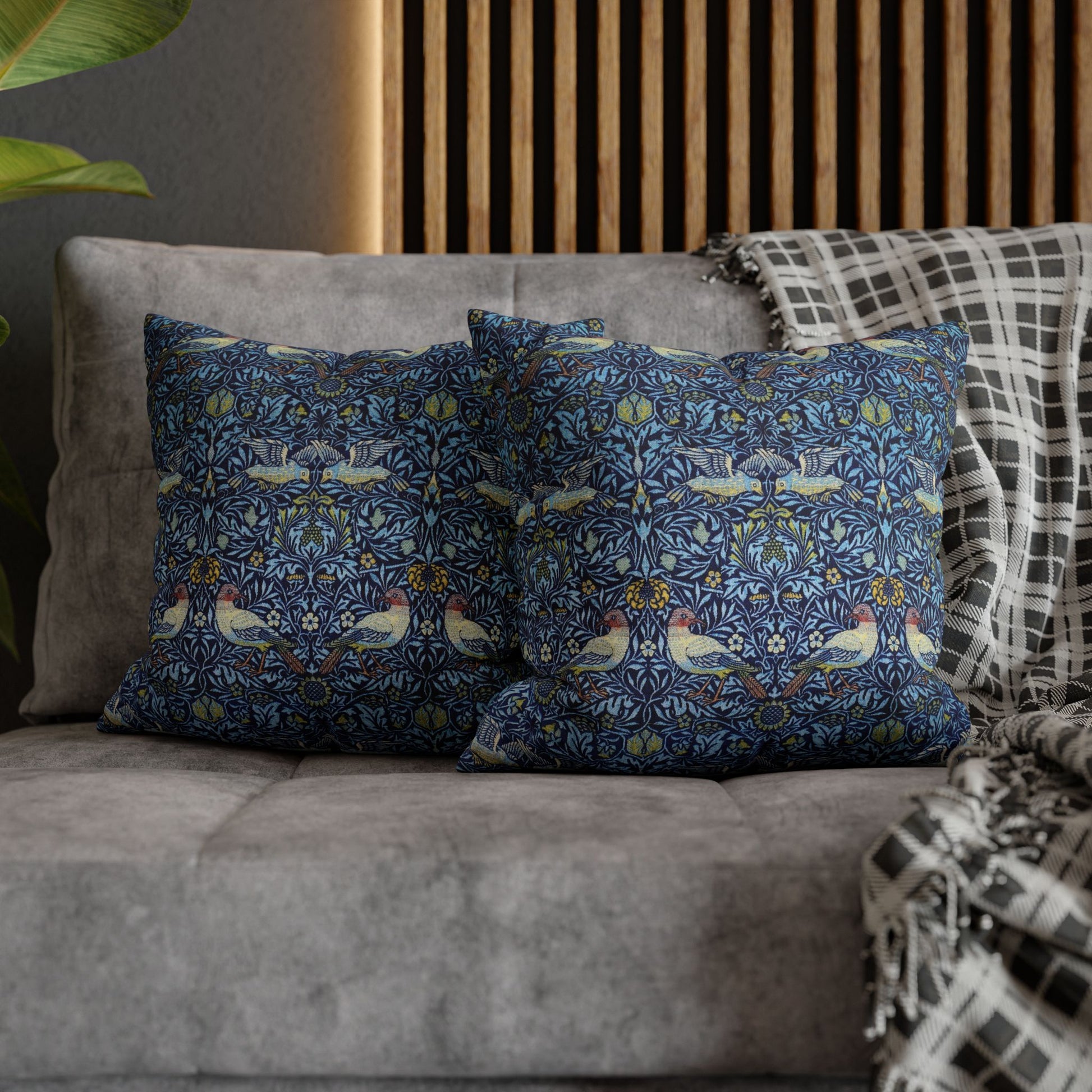 Decorative pillows with a floral pattern on a gray sofa.