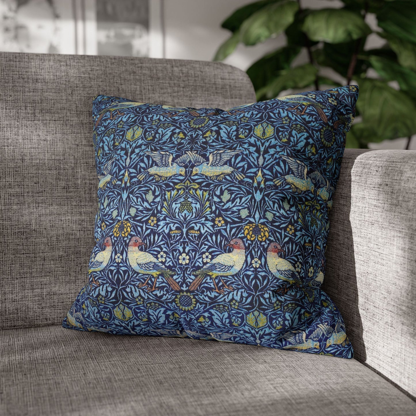 Decorative pillow with bird pattern on a gray sofa
