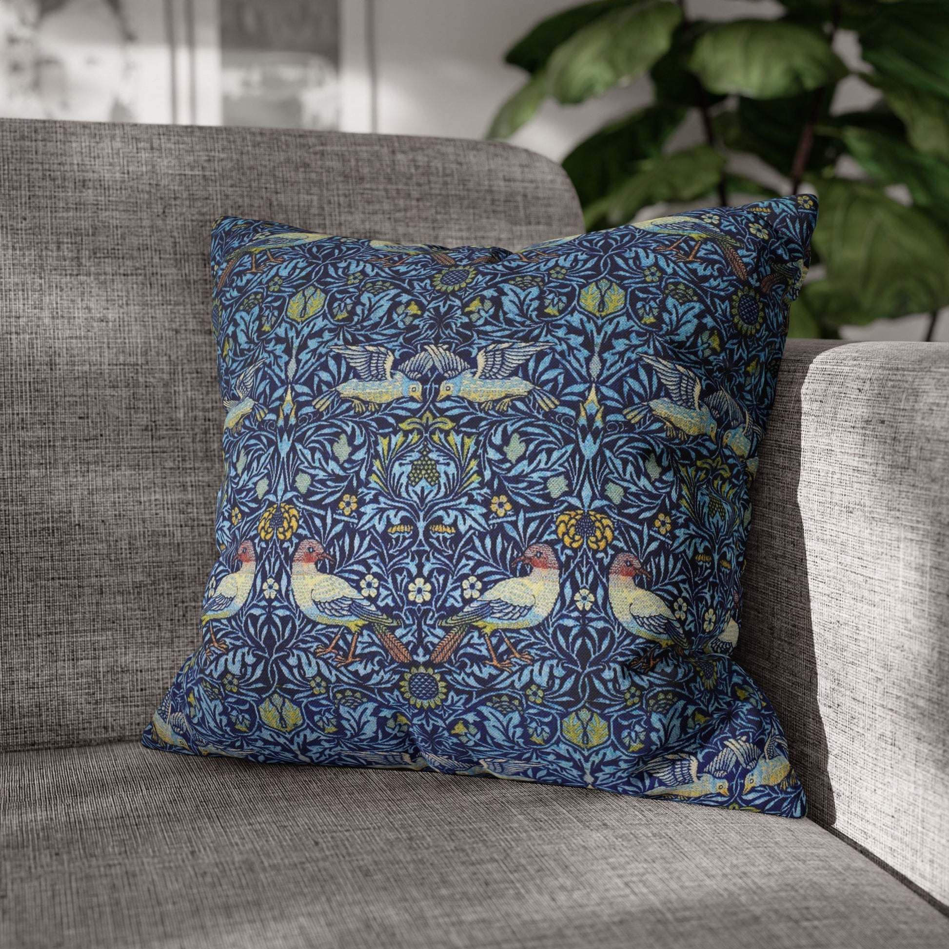 Decorative pillow with bird pattern on a gray sofa