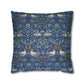 Decorative pillow with a blue pattern featuring birds and floral elements on a white background