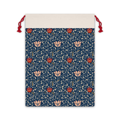 A Christmas Santa Sack with a navy background featuring an intricate floral pattern in white and red, with a cream-coloured top and red drawstrings.