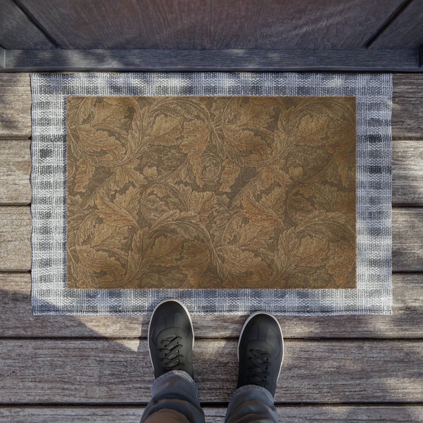 A rectangular doormat with an intricate grey pattern inspired by William Morris's designs, featuring a leaf motif. The doormat has a coarse texture and a black vinyl backing.