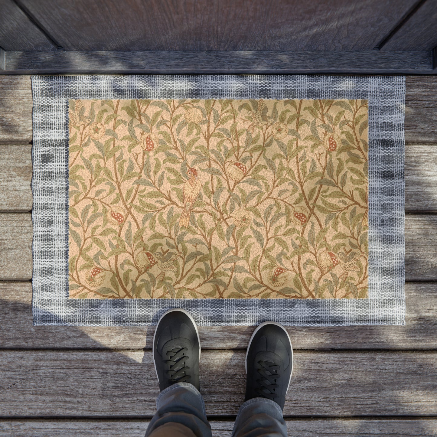 A rectangular coconut coir doormat with an intricate William Morris-inspired bird and pomegranate pattern in a parchment colour.