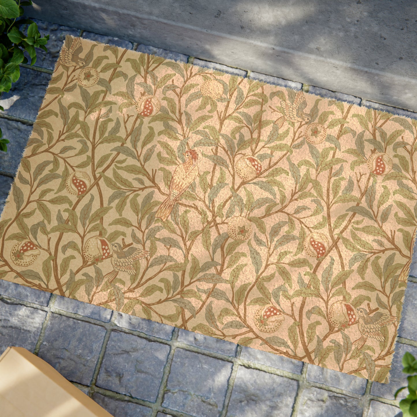 A rectangular coconut coir doormat with an intricate William Morris-inspired bird and pomegranate pattern in a parchment colour.