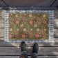 A rectangular coconut coir doormat with a floral pattern inspired by William Morris's designs, featuring a green background with multi-coloured flowers.