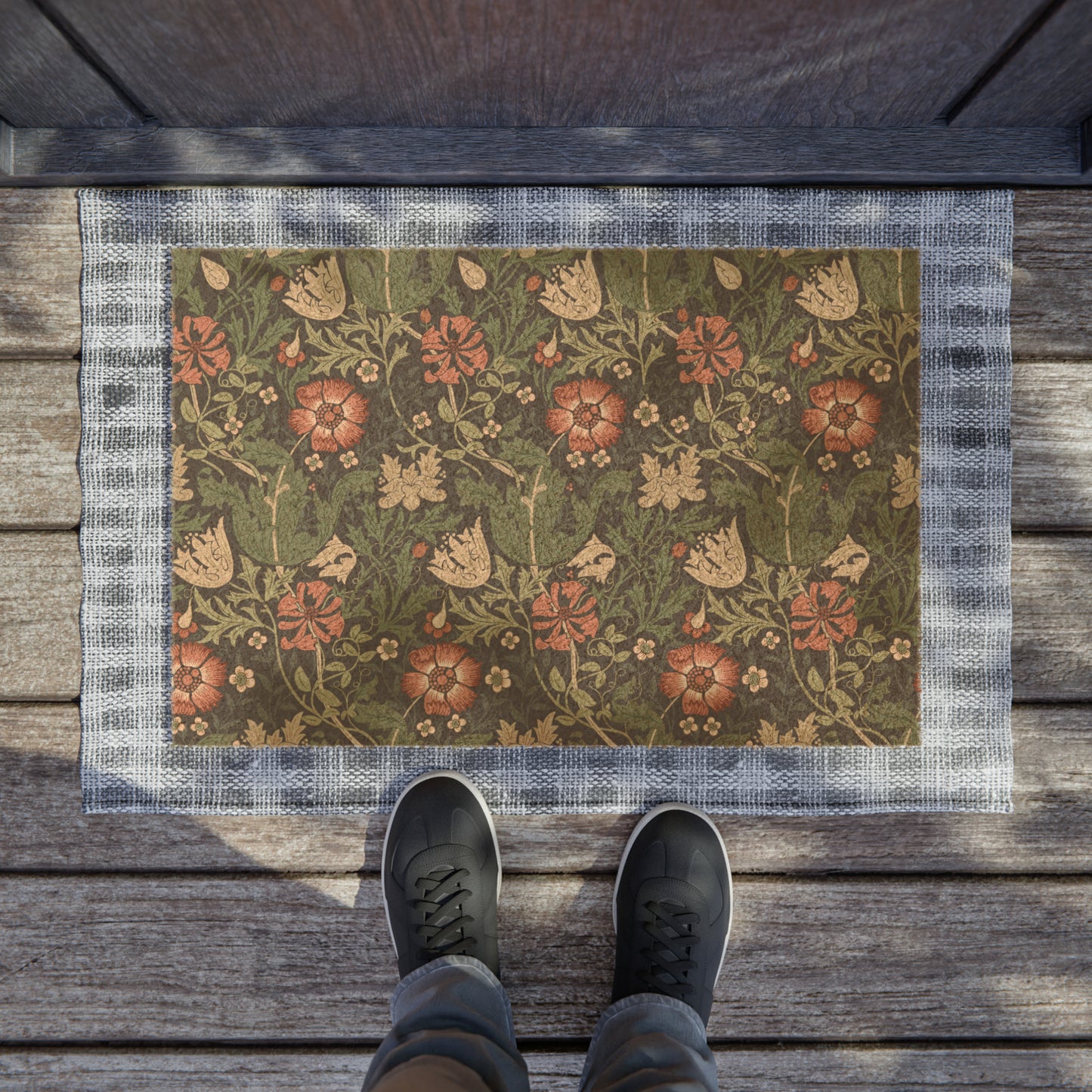 A rectangular coconut coir doormat with a floral pattern inspired by William Morris's designs, featuring a green background with multi-coloured flowers.
