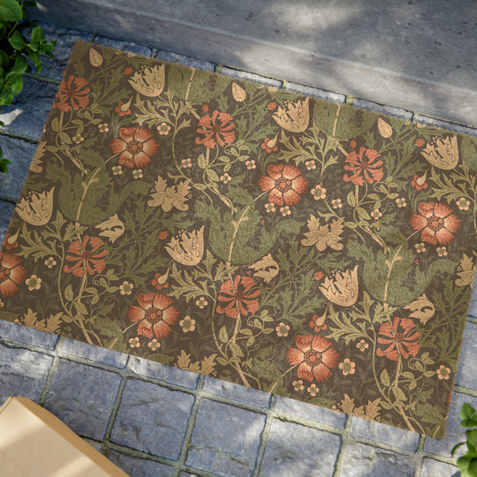 A rectangular coconut coir doormat with a floral pattern inspired by William Morris's designs, featuring a green background with multi-coloured flowers.