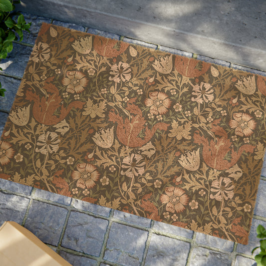 Rectangular William Morris-inspired coconut coir doormat with an floral pattern in beige, brown, and green hues.