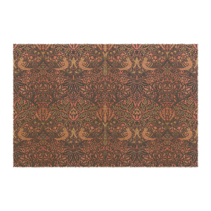 A rectangular coconut coir doormat with an intricate floral and bird William Morris & Co pattern design, primarily in pink, purple and brown colours.