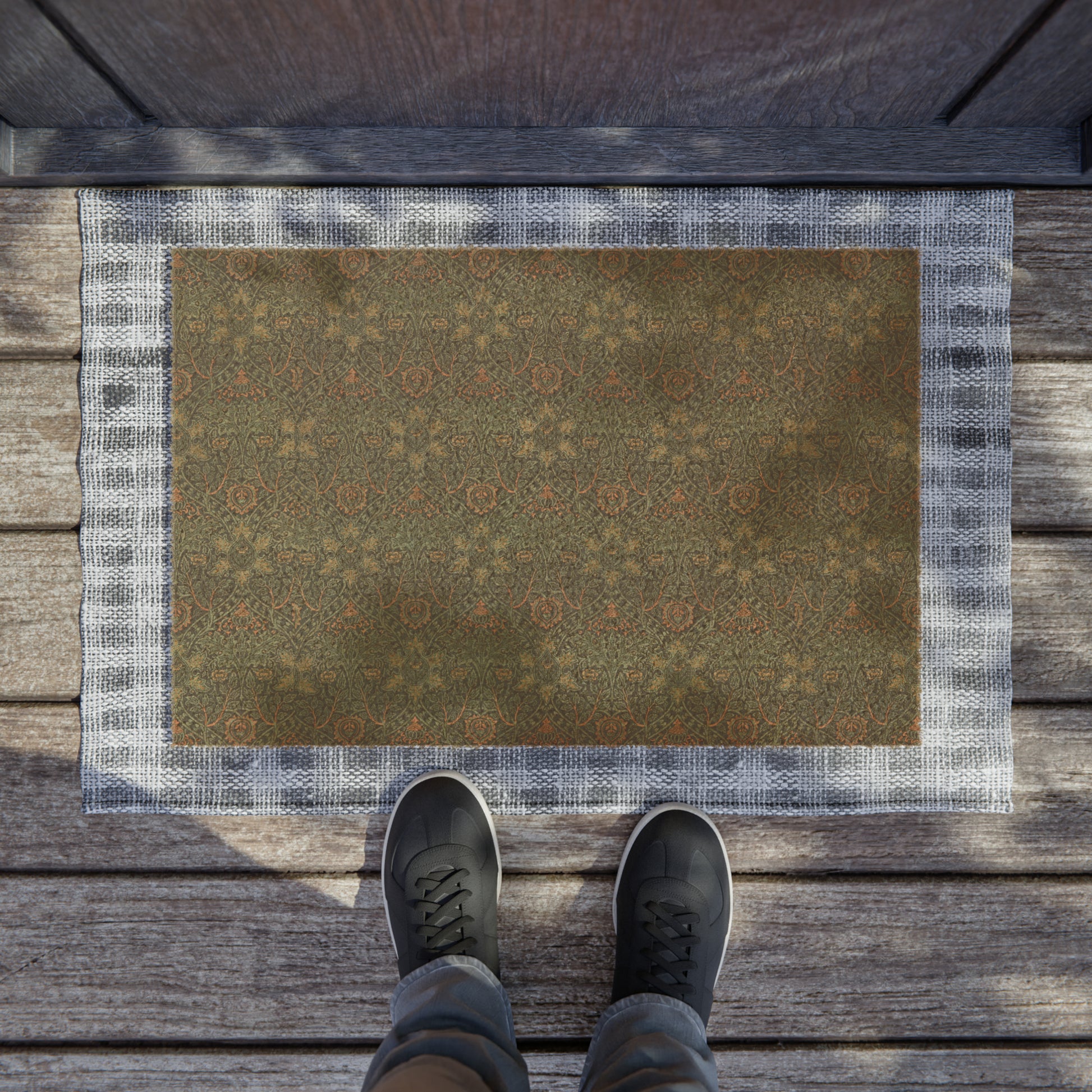 A rectangular coconut coir doormat with an intricate geometric William Morris & Co pattern and a solid brown colour.