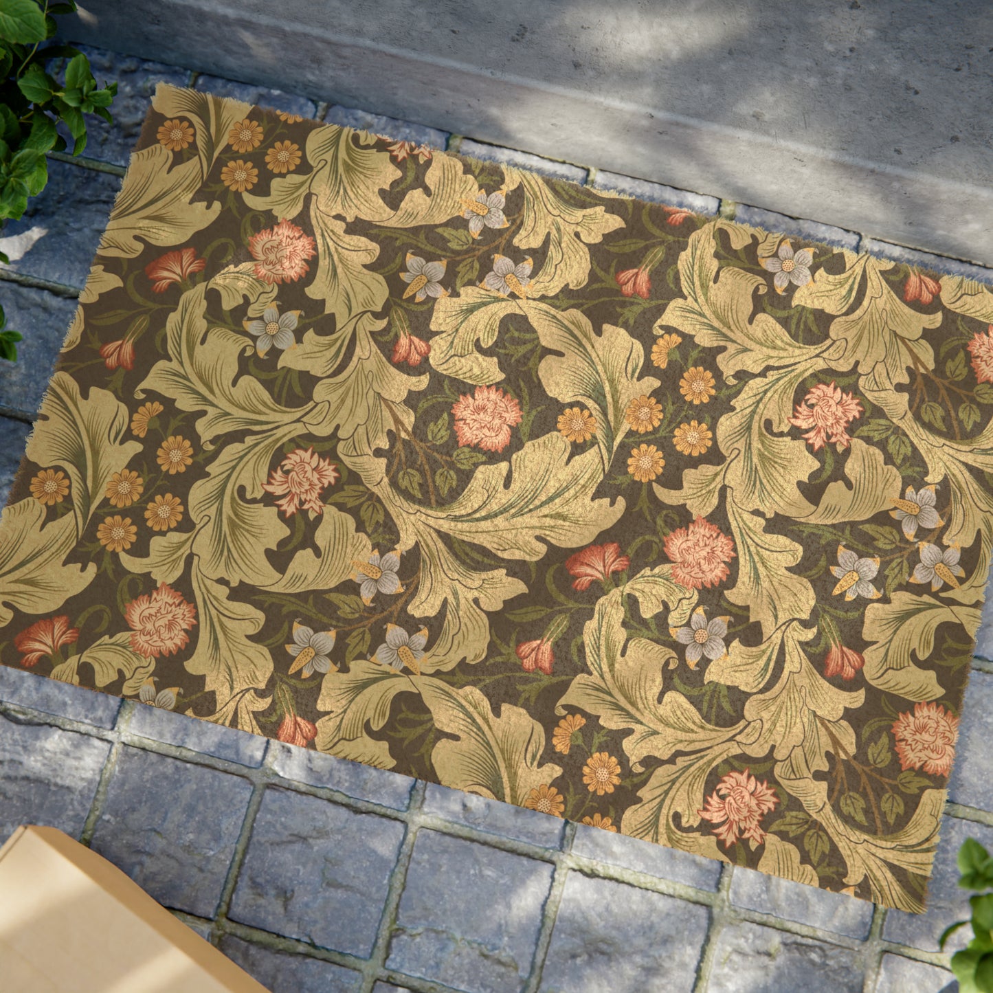 A rectangular coconut coir doormat with an intricate floral William Morris & Co pattern in green and brown colours, featuring a black vinyl backing.