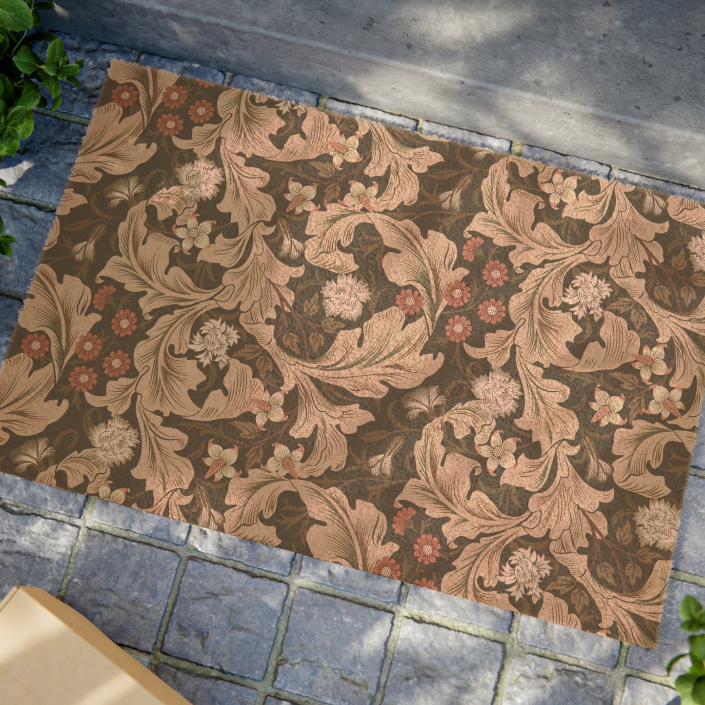 A rectangular coconut coir doormat with a floral William Morris & Co pattern in shades of brown and black.