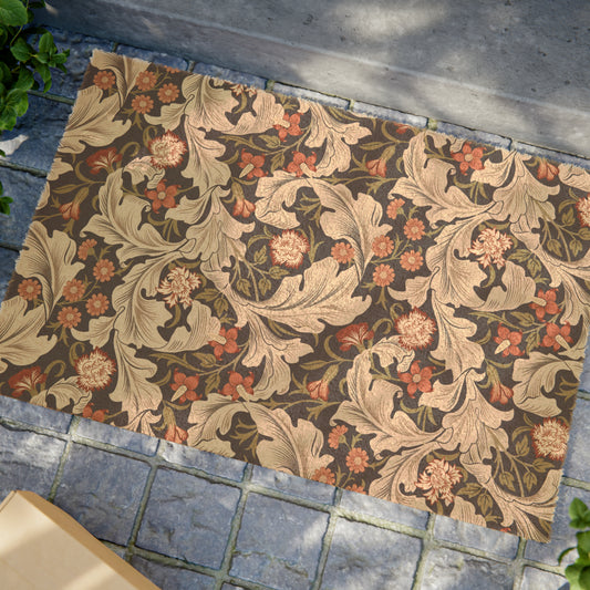 A rectangular coconut coir doormat with a floral pattern inspired by William Morris, featuring a mix of brown, beige, and green colours.