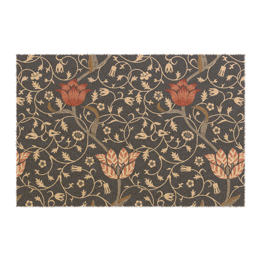 A rectangular coconut coir doormat with an intricate floral William Morris & Co pattern design, featuring a combination of dark and lighter shades, and a visible brush border at the top.