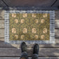 A rectangular green coconut coir doormat with an intricate floral pattern inspired by William Morris's designs, featuring a tufted coir coconut fiber texture and a black vinyl backing.