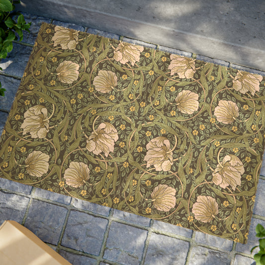 A rectangular green coconut coir doormat with an intricate floral pattern inspired by William Morris's designs, featuring a tufted coir coconut fiber texture and a black vinyl backing.
