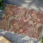 Rectangular William Morris-inspired coconut coir doormat with pink flowers and green foliage on a brown background.