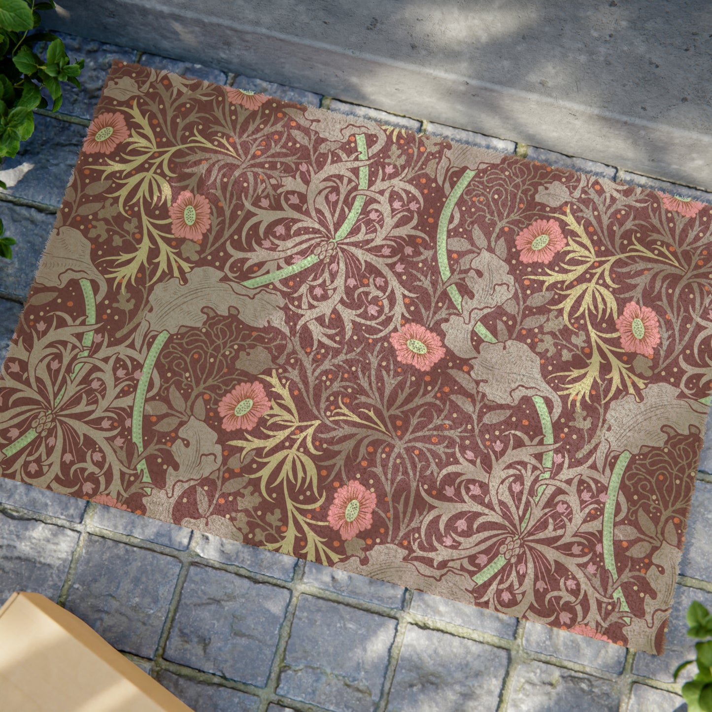 Rectangular William Morris-inspired coconut coir doormat with pink flowers and green foliage on a brown background.