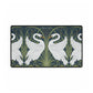 A rectangular desk mat with a floral and swan William Morris & Co pattern design, featuring a white background and swans, placed under a white mouse pad with a keyboard on top.