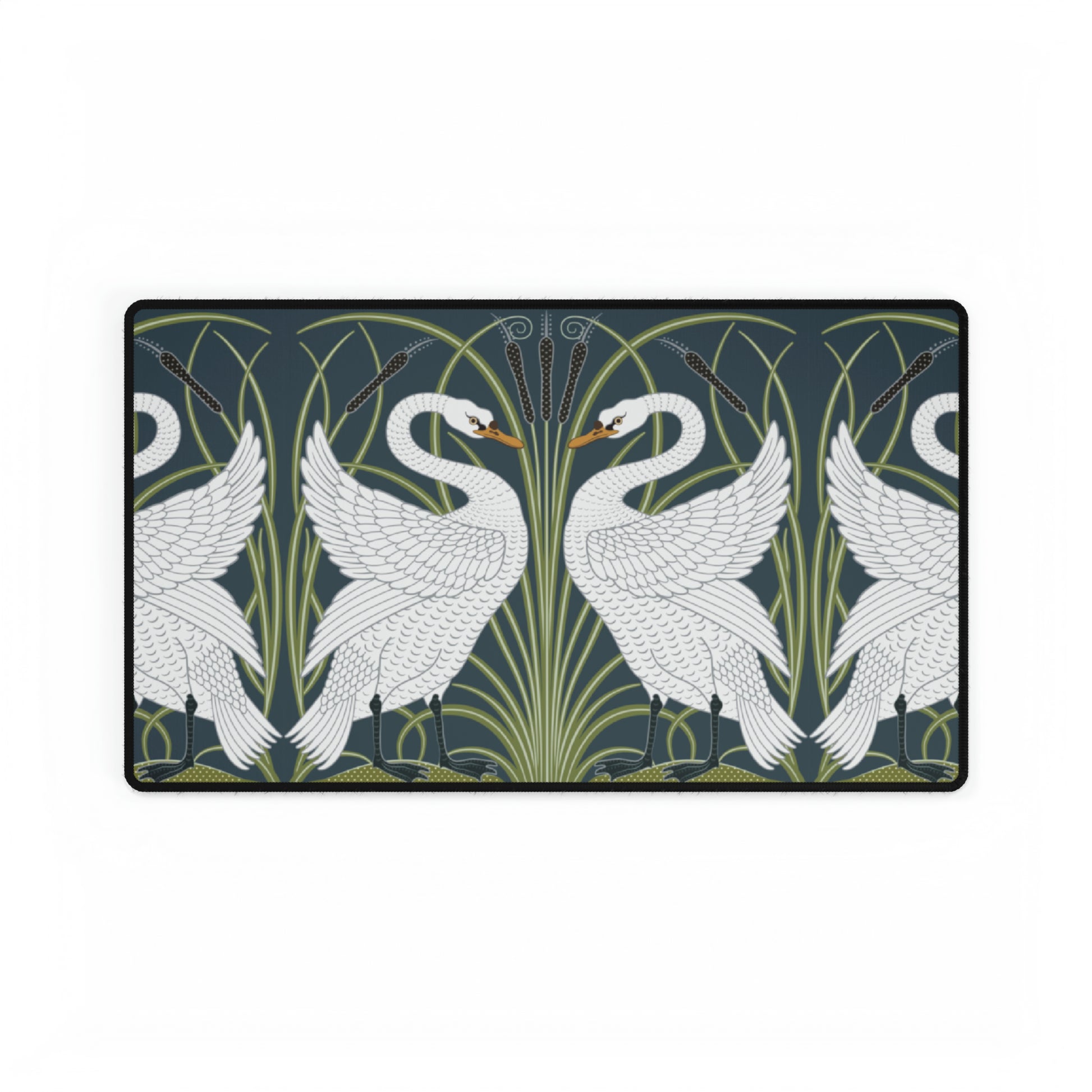 A rectangular desk mat with a floral and swan William Morris & Co pattern design, featuring a white background and swans, placed under a white mouse pad with a keyboard on top.