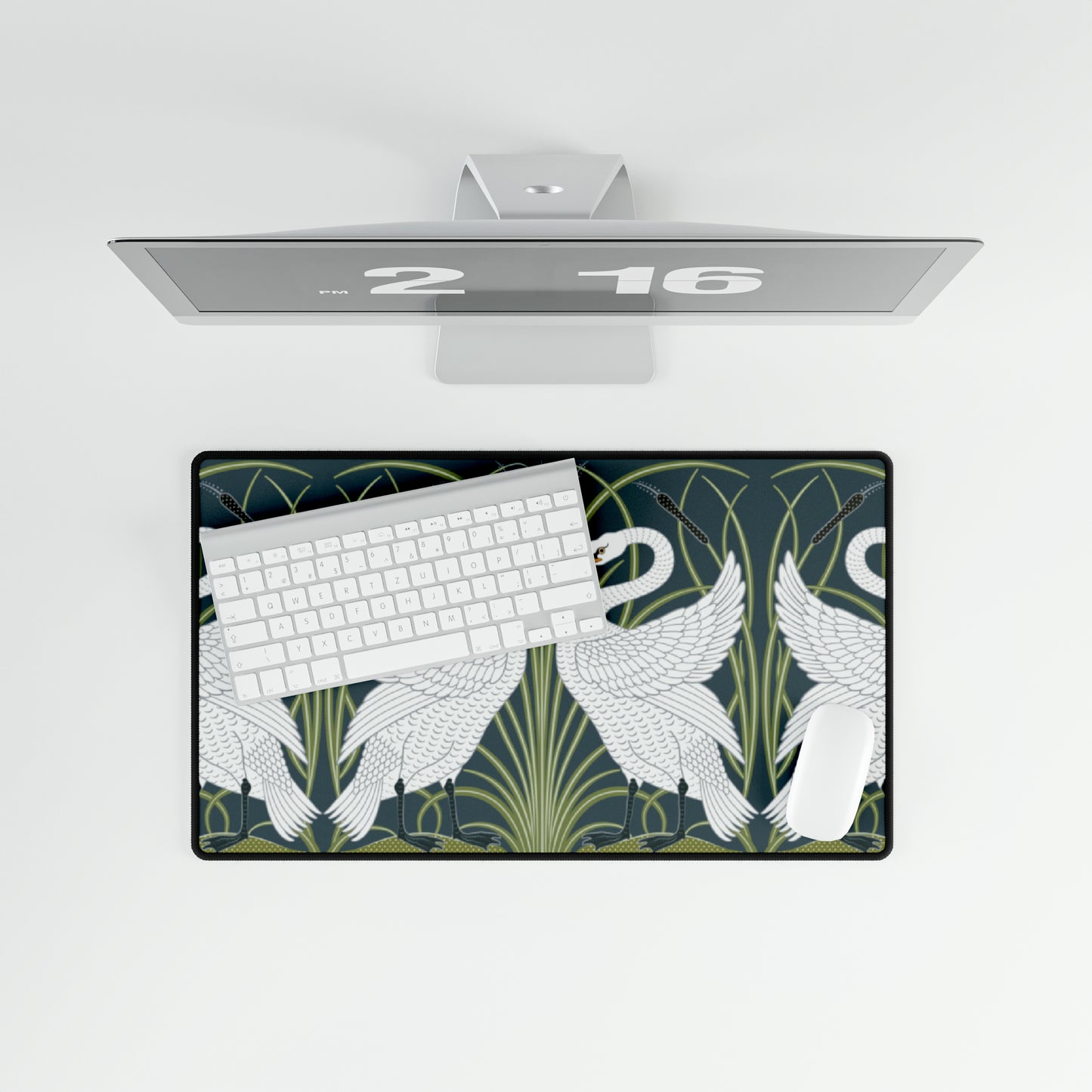 A rectangular desk mat with a floral and swan William Morris & Co pattern design, featuring a white background and swans, placed under a white mouse pad with a keyboard on top.