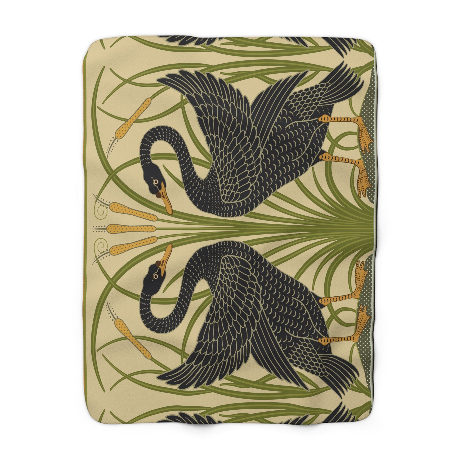 A Sherpa fleece blanket with a pattern inspired by William Morris, featuring black swans and green foliage on a beige background.