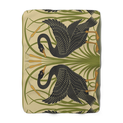 A Sherpa fleece blanket with a pattern inspired by William Morris, featuring black swans and green foliage on a beige background.