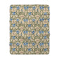 A Sherpa fleece blanket with a floral William Morris & Co pattern in blue and green on a beige background.