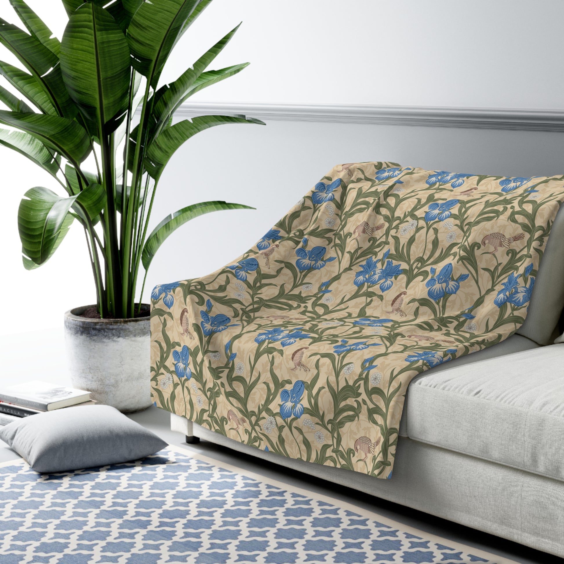 A Sherpa fleece blanket with a floral William Morris & Co pattern in blue and green on a beige background.