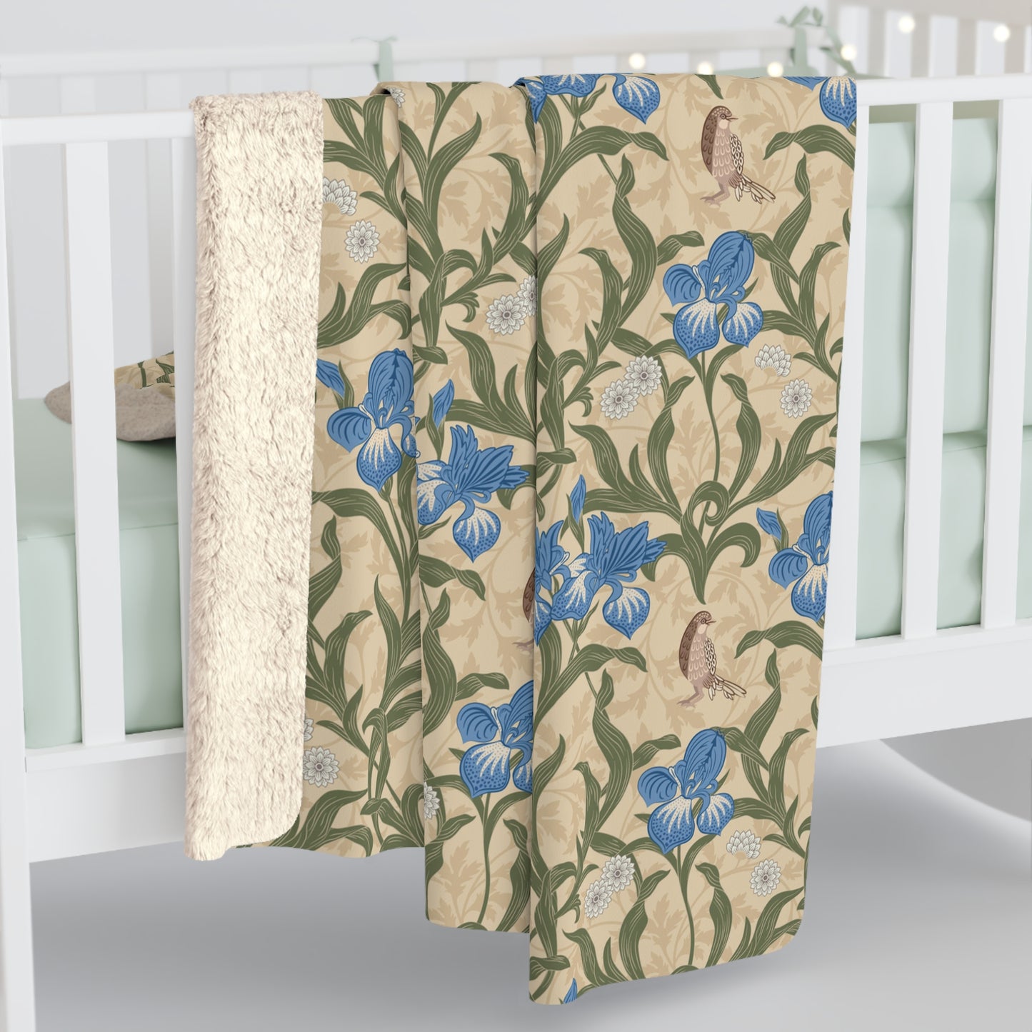 A Sherpa fleece blanket with a floral William Morris & Co pattern in blue and green on a beige background.