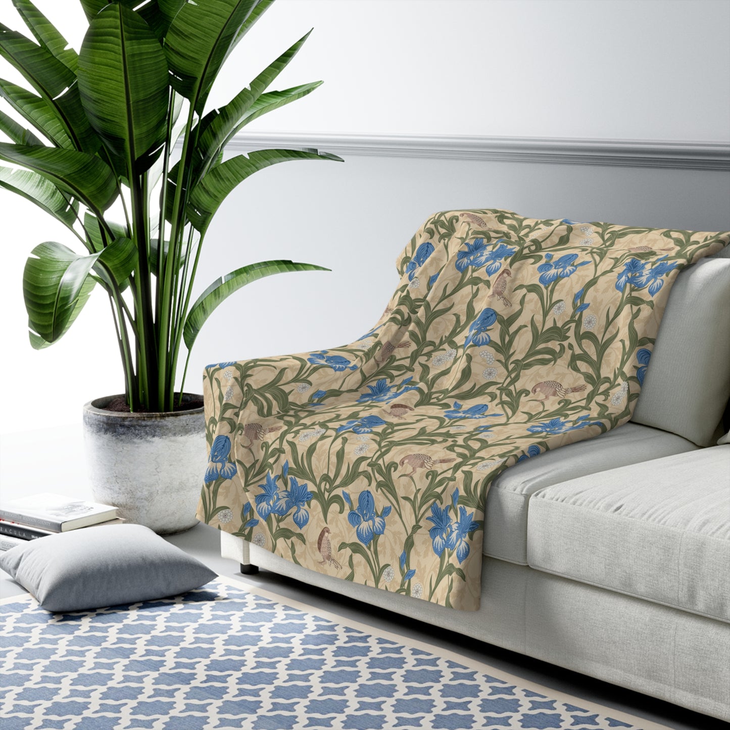 A Sherpa fleece blanket with a floral William Morris & Co pattern in blue and green on a beige background.