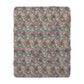 A cozy fluffy fleece blanket with a floral William Morris & Co pattern in various colours, laid flat.