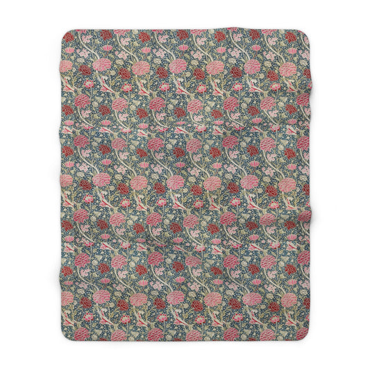 A cozy fluffy fleece blanket with a floral William Morris & Co pattern in various colours, laid flat.
