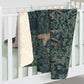 A Sherpa fleece blanket with an intricate floral and tree design, primarily in green and red tones, reflecting a natural and rustic theme.