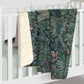 A Sherpa fleece blanket with an embossed design featuring rabbits, foxes, and green foliage on a green background.