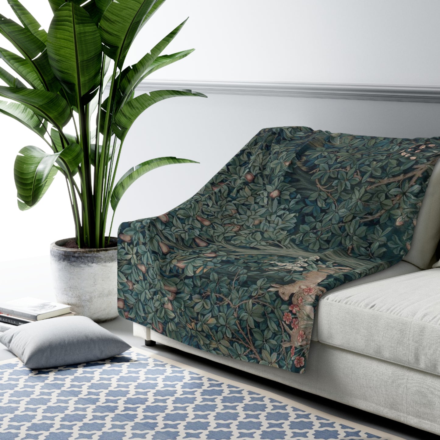 A Sherpa fleece blanket with an embossed design featuring rabbits, foxes, and green foliage on a green background.