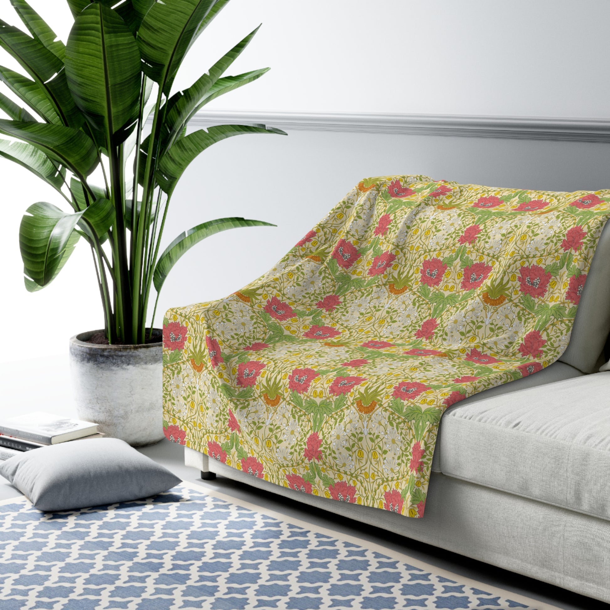 A Sherpa fleece blanket with a floral pattern in pink and yellow hues on a green background, displayed flat.