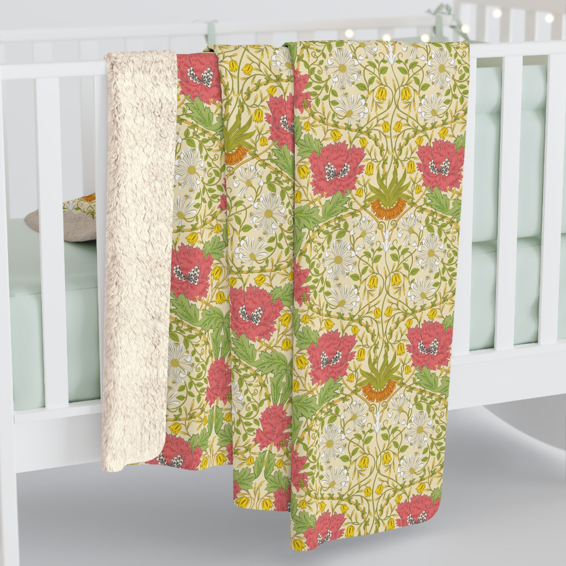 A Sherpa fleece blanket with a floral pattern in pink and yellow hues on a green background, displayed flat.